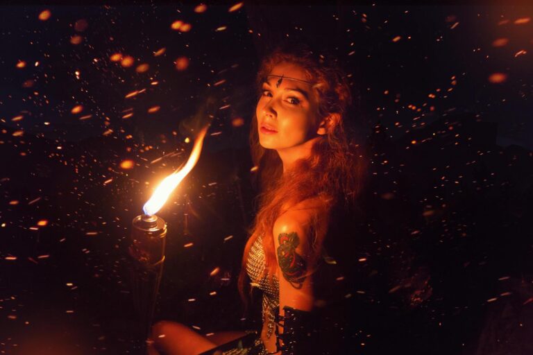 a woman holding a fire torch in the night