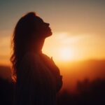a woman's silhouette in front of the sunrise