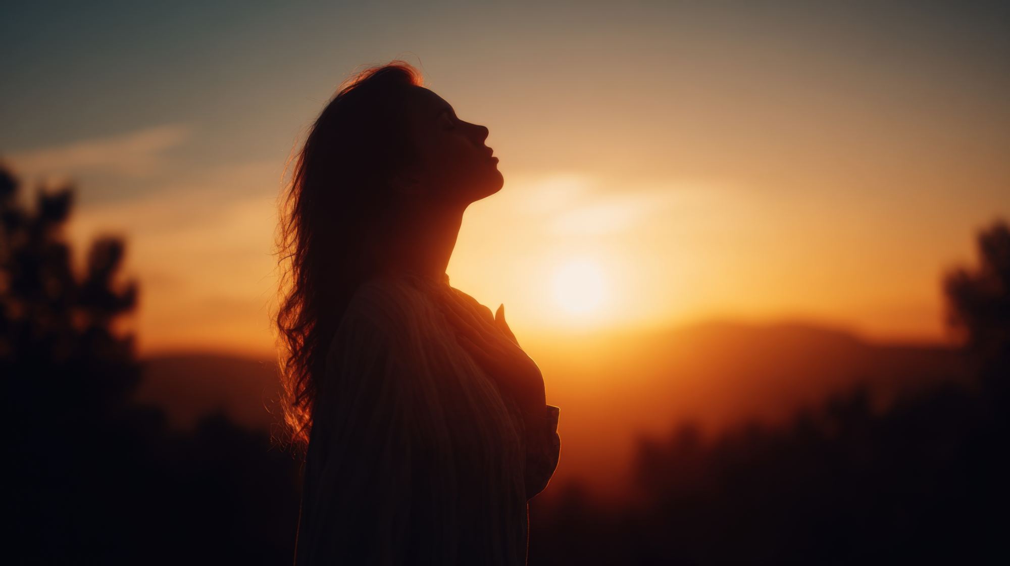 a woman's silhouette in front of the sunrise