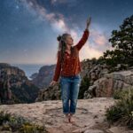 a woman standing on a cliff